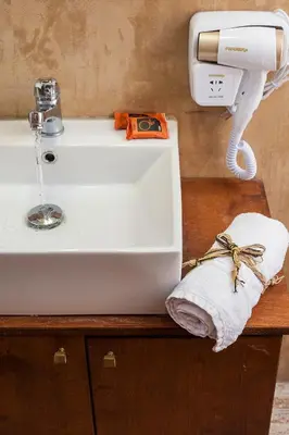 a bathroom sink with a soap dispenser and a towel at Hamam Suites Sifaka in Chania Town