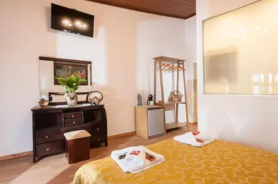 a bedroom with a bed and a dresser and a mirror at Hamam Suites Sifaka in Chania Town