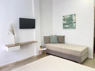 a room with a bed and a tv on a wall at Katerina Sea Apartments in Chania Town