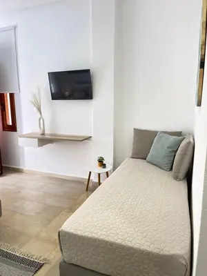 a room with a bed and a tv on a wall at Katerina Sea Apartments in Chania Town