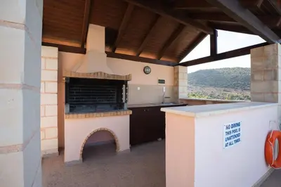an outdoor kitchen with a fireplace in a house at Villa Petra- Panormic Sea view - Private Pool in Kalyves