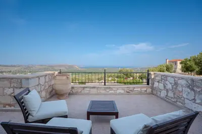 a patio with chairs and a table and a view at Villa Petra- Panormic Sea view - Private Pool in Kalyves
