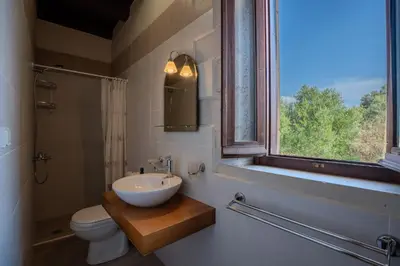 a bathroom with a sink and a toilet and a window at Villa Petra- Panormic Sea view - Private Pool in Kalyves