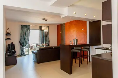 a kitchen and living room with a couch and a table at Sandy Point Villas Chania in Agia Marina Nea Kydonias