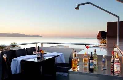 a table with bottles of alcohol on a balcony at Sandy Point Villas Chania in Agia Marina Nea Kydonias