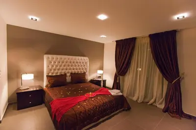 a bedroom with a bed with a red ribbon on it at Sandy Point Villas Chania in Agia Marina Nea Kydonias