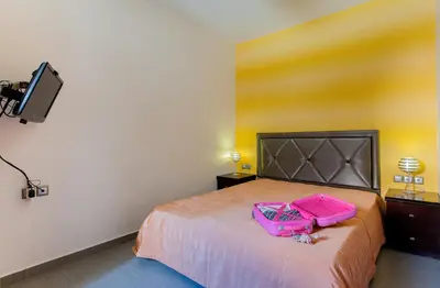 a bedroom with a bed with two pink bags on it at Sandy Point Villas Chania in Agia Marina Nea Kydonias