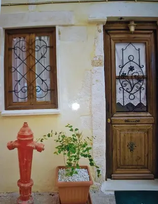 a red fire hydrant next to a building with a door at Villa Margot in Chania Town