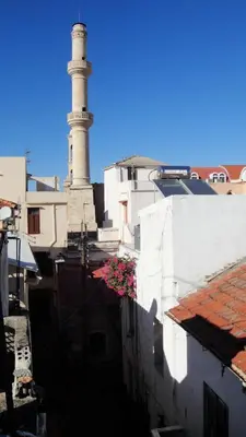 a lighthouse in the middle of a city with buildings at Villa Margot in Chania Town