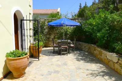 a patio with a table with a blue umbrella at Villa Rodi in Gavalochori