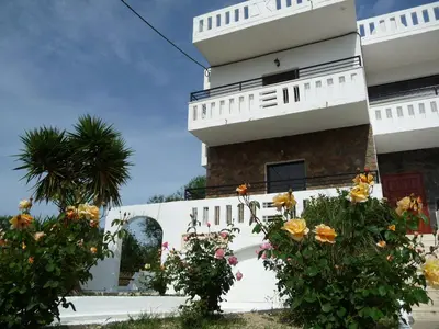 a white building with flowers in front of it at Zourpos Studios in Kalyves