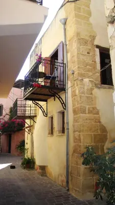 a building with a balcony with flowers on it at Old Stone House in Chania Town