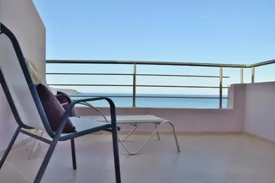 a room with a chair and a table on a balcony at Rubini Homes in Agia Marina Nea Kydonias