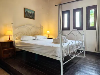 a white bed in a bedroom with two lamps at Anna-Malai Penthouse in Megála Khoráfia
