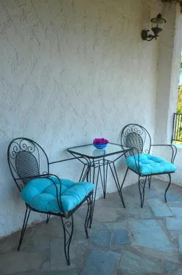 a table and two chairs and a table with blue cushions at Anna-Malai Penthouse in Megála Khoráfia