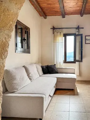 a living room with a couch and a window at Anna-Malai Penthouse in Megála Khoráfia