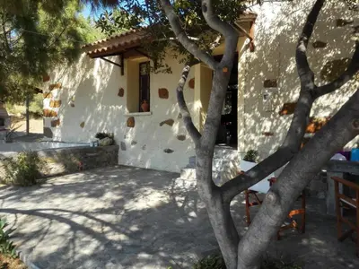 a white house with a tree in front of it at Trouli House in Stalos