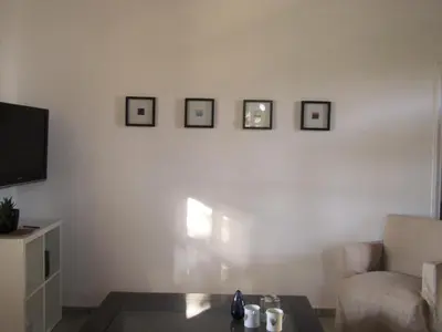 a living room with a couch and three pictures on the wall at Trouli House in Stalos