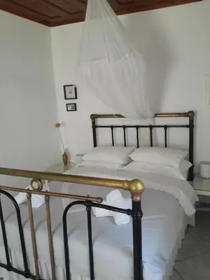 a bedroom with a large bed with white sheets at Trouli House in Stalos