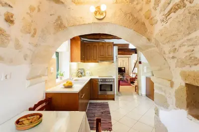 a kitchen with a stone wall and an archway at Tzitzifes Stone Mansion in Tzitzifés