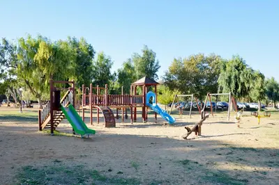 a playground with a monkey running around in a park at Katerina Rooms Agii Apostoloi in Kato Daratso