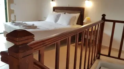 a bed with white sheets and pillows in a bedroom at Filippou Villa - Living in Nature in Fílippos