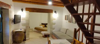 a living room with a couch and a tv at Filippou Villa - Living in Nature in Fílippos