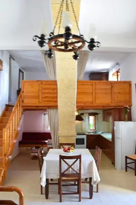 a dining room with a table and a staircase at Filippou Villa - Living in Nature in Fílippos