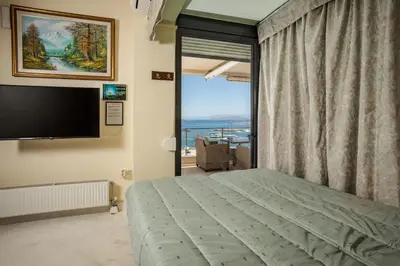 a bedroom with a bed and a large window at Panoramic Sea View in Chania Town
