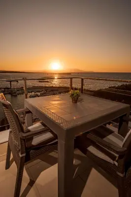 a table on a balcony with the sunset in the background at Panoramic Sea View in Chania Town