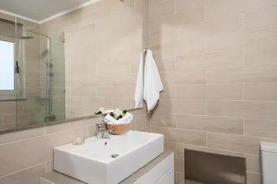 a bathroom with a sink and a mirror at Cedar Bay Beachside Villas in Palaiochóra