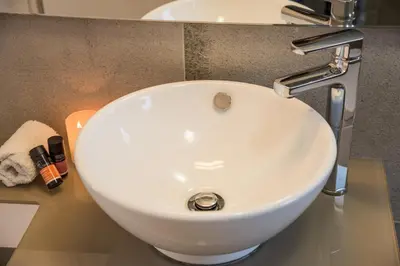 a white bathroom sink sitting on a counter at Cedar Bay Beachside Villas in Palaiochóra