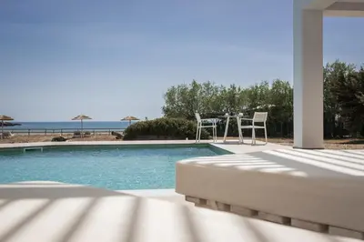 a villa with a pool and a table and chairs at Cedar Bay Beachside Villas in Palaiochóra