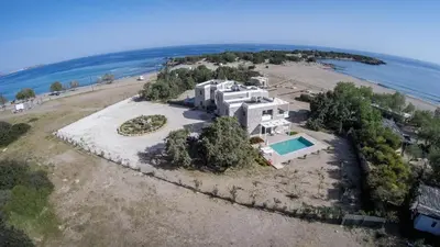 an aerial view of a large house on a beach at Cedar Bay Beachside Villas in Palaiochóra