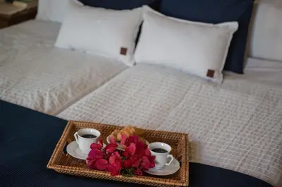 a tray with two cups and flowers on a bed at Antheia Houses in Vamos