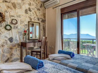 a bedroom with two beds and a desk and a window at Villa Kalliani in Kissamos