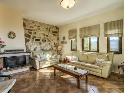 a living room with two couches and a fireplace at Villa Kalliani in Kissamos