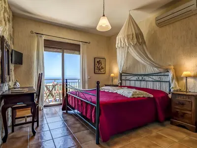 a bedroom with a bed and a table and a window at Villa Kalliani in Kissamos