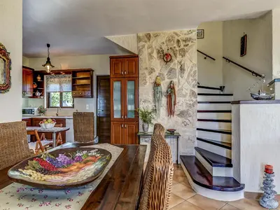 a kitchen and dining room with a table with a bowl of fruit at Villa Kalliani in Kissamos