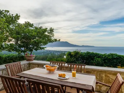 a table with a bowl of oranges on top of a balcony at Villa Kalliani in Kissamos