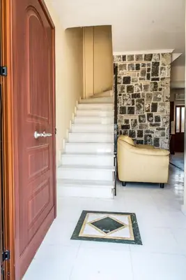 a hallway with a door and stairs with a stone wall at Erodios Villas 1 in Gerani Chanion