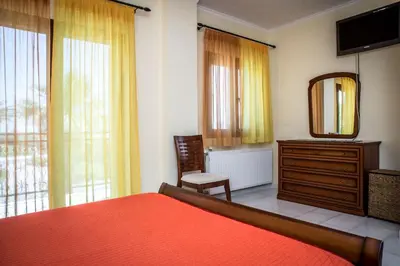 a bedroom with a bed and a dresser and a mirror at Erodios Villas 1 in Gerani Chanion