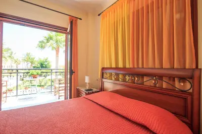 a bedroom with a bed and a large window at Erodios Villas 1 in Gerani Chanion