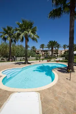 a large swimming pool with palm trees in the background at Erodios Villas 1 in Gerani Chanion