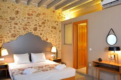 a bedroom with a bed and a stone wall at Elia Kentron in Chania Town