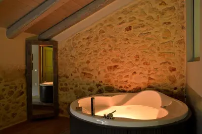 a bathroom with a bath tub with a stone wall at Elia Kentron in Chania Town
