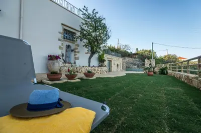a hat is sitting on a bench in a yard at Villa Panareti in Kolymvari