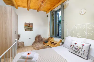 a bedroom with a white bed and a window at Villa Panareti in Kolymvari