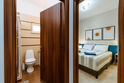 a bedroom with a bed and a toilet in a room at Harmony Apartments in Kato Daratso