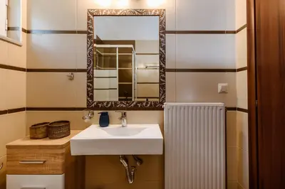 a bathroom with a sink and a mirror and a radiator at Harmony Apartments in Kato Daratso